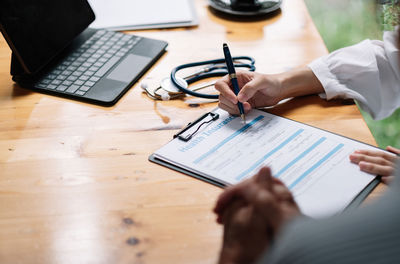 Midsection of businessman working on table