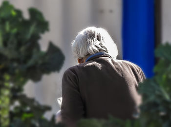 Rear view of a woman against plants