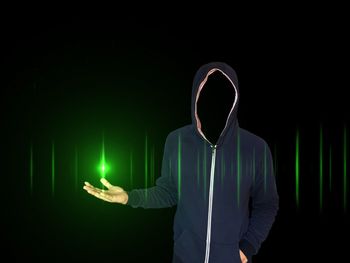Digital composite image of man with obscured face against black background