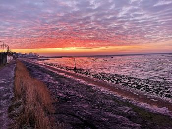 Panoramic view of sea against dramatic sky during sunset