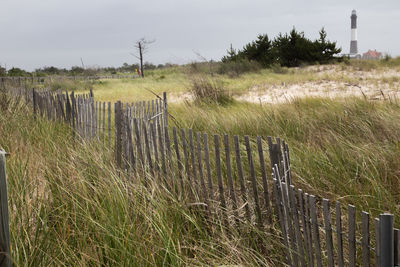 Wooden fence on field against sky