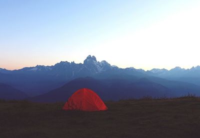 Tent on field against mountain range against clear sky