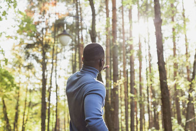 Rear view of man standing in forest