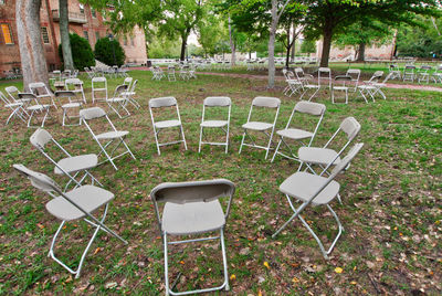 Empty chairs and table on field