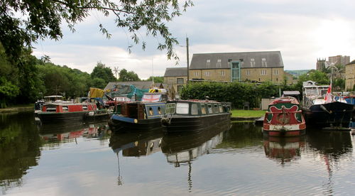 Boats moored in lake against built structures