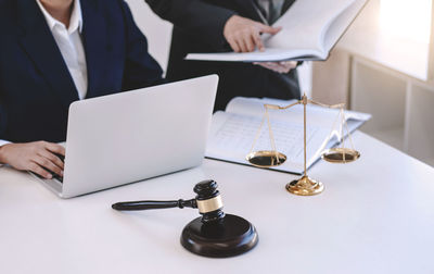Midsection of man using laptop on table