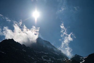 Low angle view of snowcapped mountains against sky