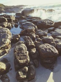 Close-up of stones on beach against sky