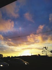 Silhouette street against sky during sunset