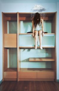 Low section of woman standing on wooden floor at home