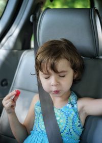 Cute girl eating candy in car