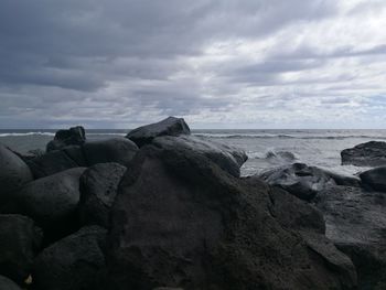 Rocks on beach against sky