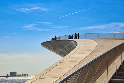 Low angle view of people on building against sky