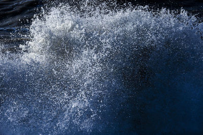 Close-up of bubbles over sea against black background