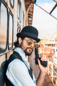 Portrait of young man holding hat