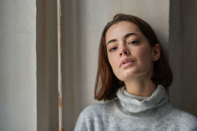 Portrait of woman against wall