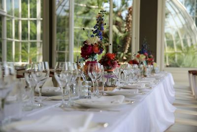 Flower vase and wineglasses on dining table