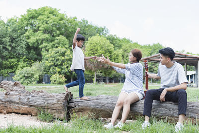 Full length of couple sitting on rock