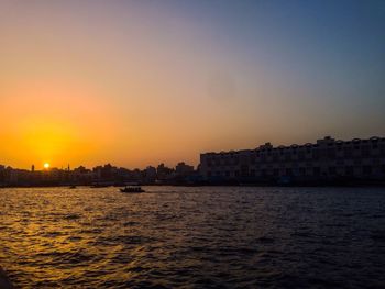 Sunset over river with buildings in background