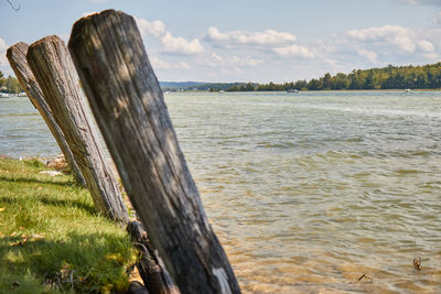 Wooden posts on beach against sky