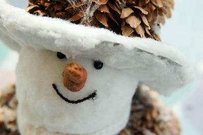 Very close up portrait of a snowman toy looking ahead