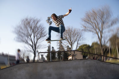 Portrait of skateboarder jumping with a ramp