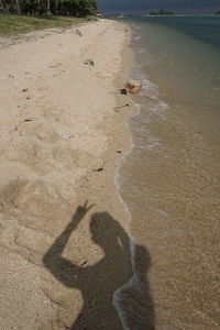 Shadow of man on sand at beach