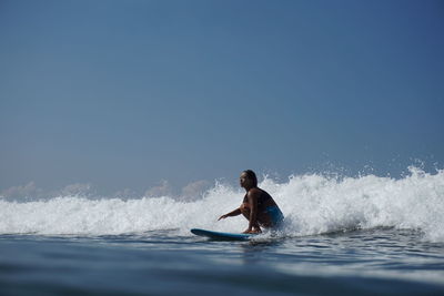 Man surfing in sea against clear sky