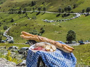 Food on folding chair against grassy landscape