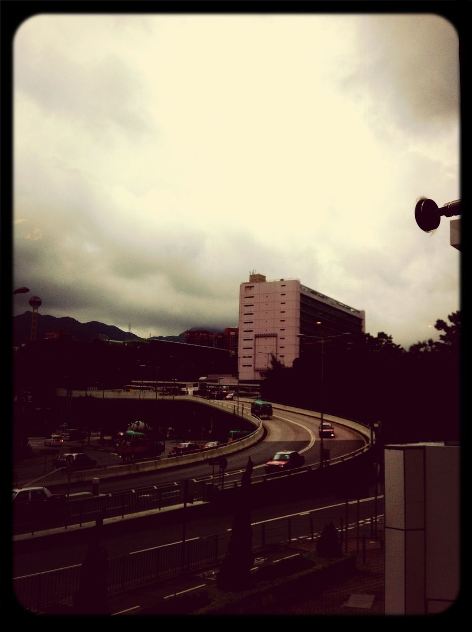 sky, architecture, built structure, transportation, building exterior, transfer print, cloud - sky, land vehicle, cloudy, auto post production filter, city, car, mode of transport, dusk, street, illuminated, road, cloud, overcast, weather