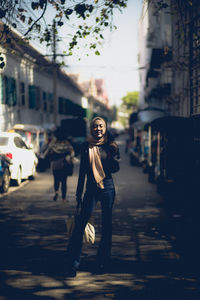 Woman with umbrella on street in city