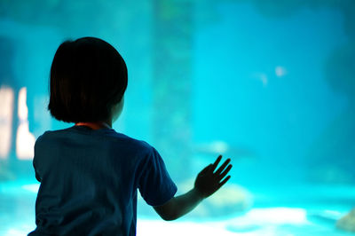 Rear view of girl looking at fish tank