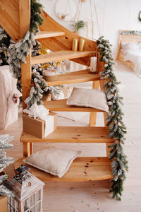 Wooden staircase in the apartment is decorated with christmas tree branches