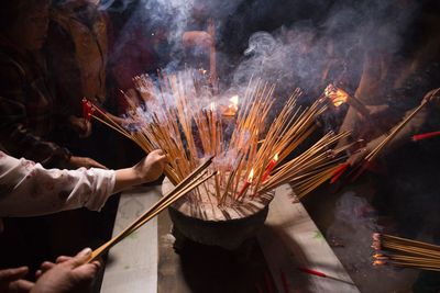 People burning incense sticks at temple