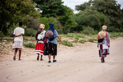 Rear view of people walking on road