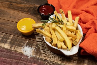 Tasty french fries on plate on wooden table background