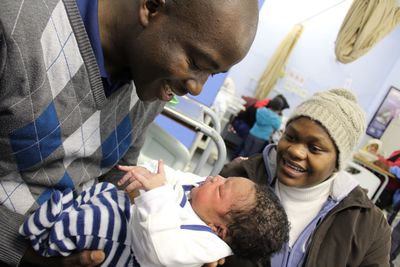 Close-up of father holding newborn son at hospital