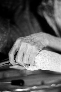 Cropped wrinkled hand holding railing