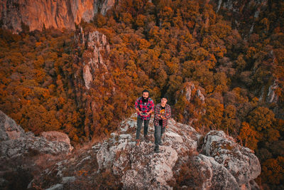 Woman standing on rock with autumn leaves