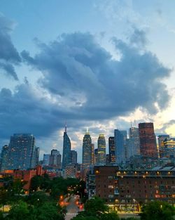 Buildings in city against cloudy sky