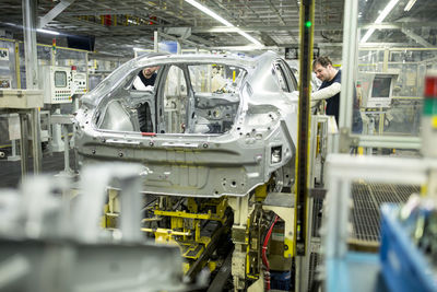 Two colleagues working in modern car factory