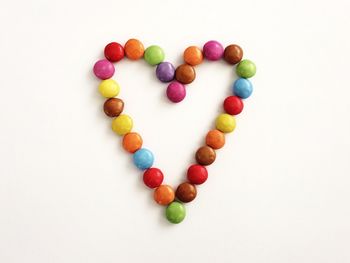 Close-up of multi colored heart shape on white background