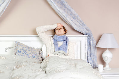 Midsection of woman lying on bed