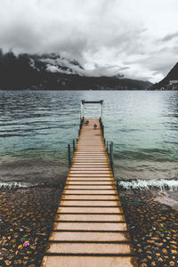 Boardwalk amidst sea against sky