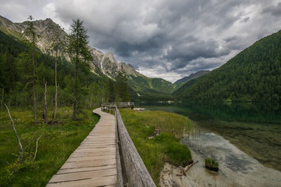 Footbridge over lake against sky