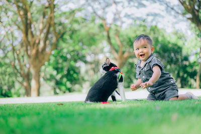 Cute boy with dog against plants