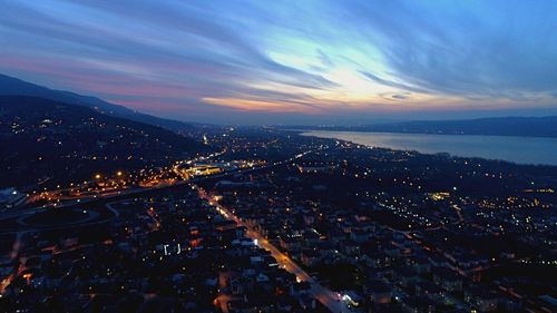 High angle view of illuminated city against sky at sunset