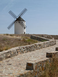 Traditional windmill on landscape against sky