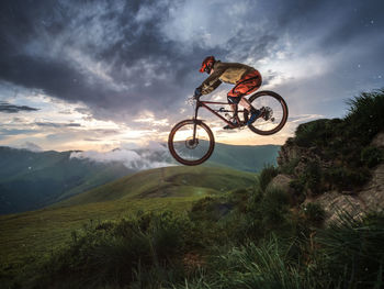 Full length of man with bicycle against cloudy sky