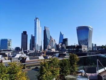 Modern buildings in city against blue sky